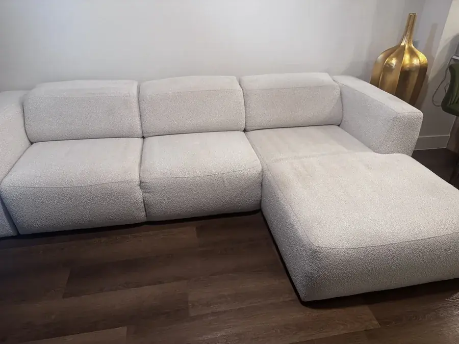 White boucle sectional with chaise before cleaning, grayed by dirt and food stains, in a Houston apartment