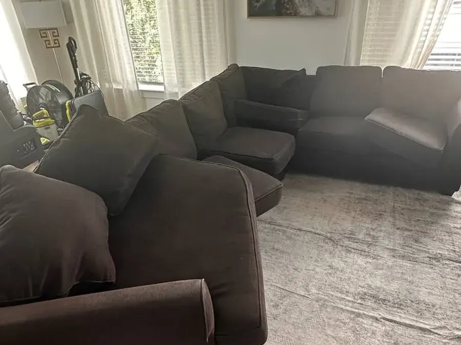 Full view of a large dark brown sectional before cleaning