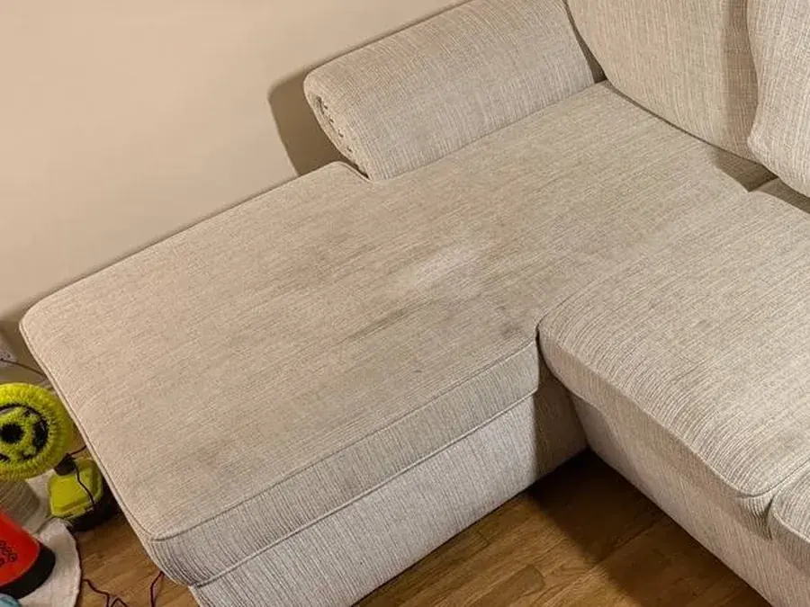 Close-up of the chaise before cleaning with dark soiled patches and food and drink stains