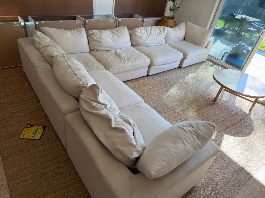 Large cream modular cloud sectional before cleaning, covered in food and drink stains and marker, in a Houston home with four kids and two dogs