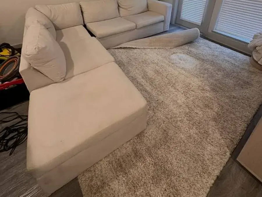 Cream fabric sectional with chaise before cleaning, with food and drink stains, in a Houston apartment
