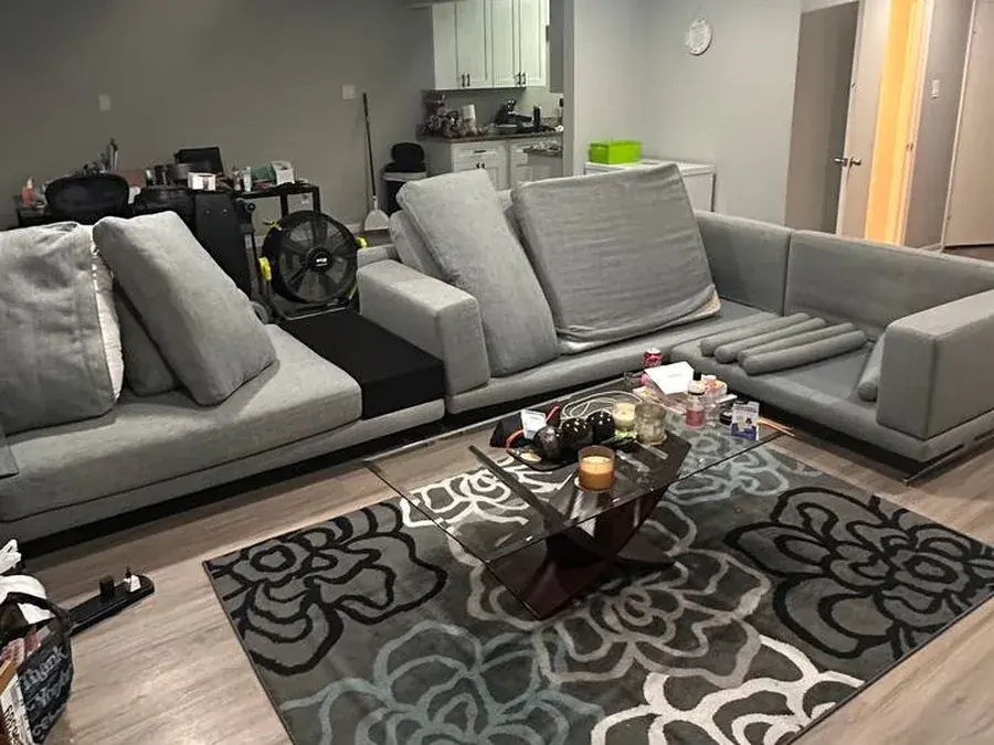 The same gray sectional after cleaning, cushions set up to dry with an air mover