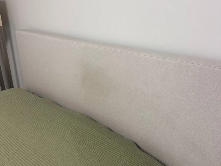 Close-up of the coffee stain spreading across the fabric headboard