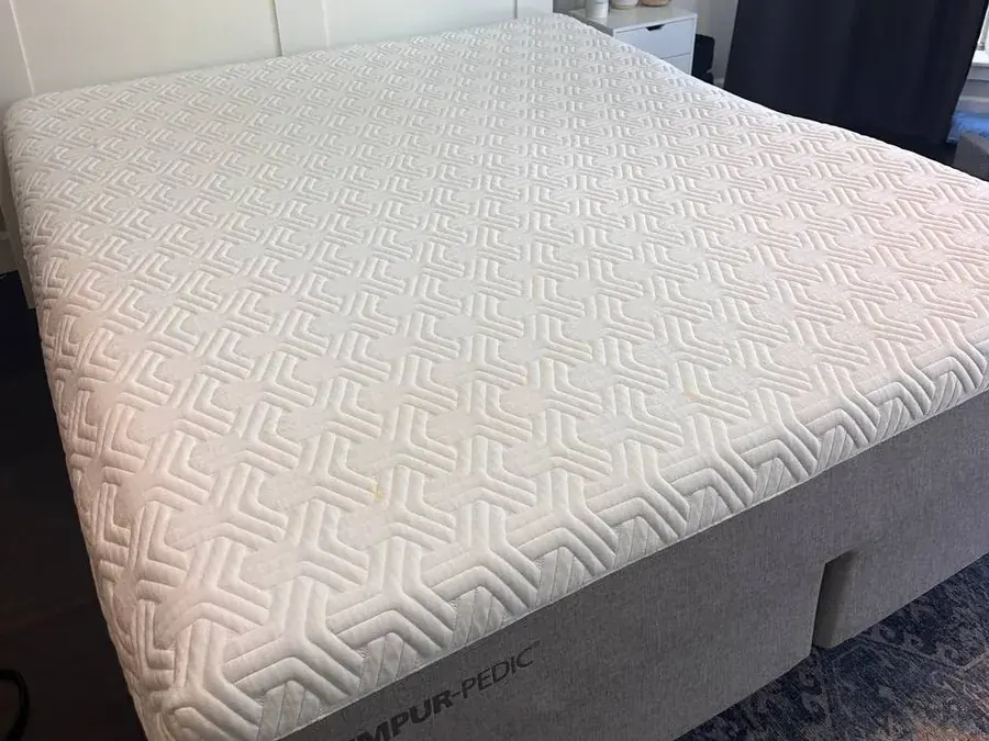 White memory foam mattress with dirt and yellow organic stains before cleaning in a Houston bedroom