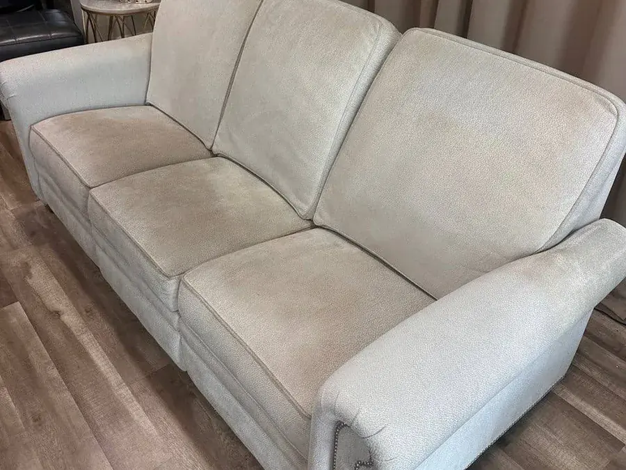 Light reclining sofa with nailhead trim before cleaning, with food and drink stains on the seats
