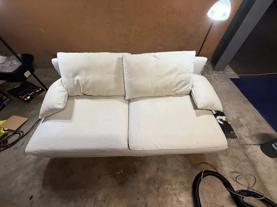 The same cream loveseat after cleaning, every stain removed, looking like new