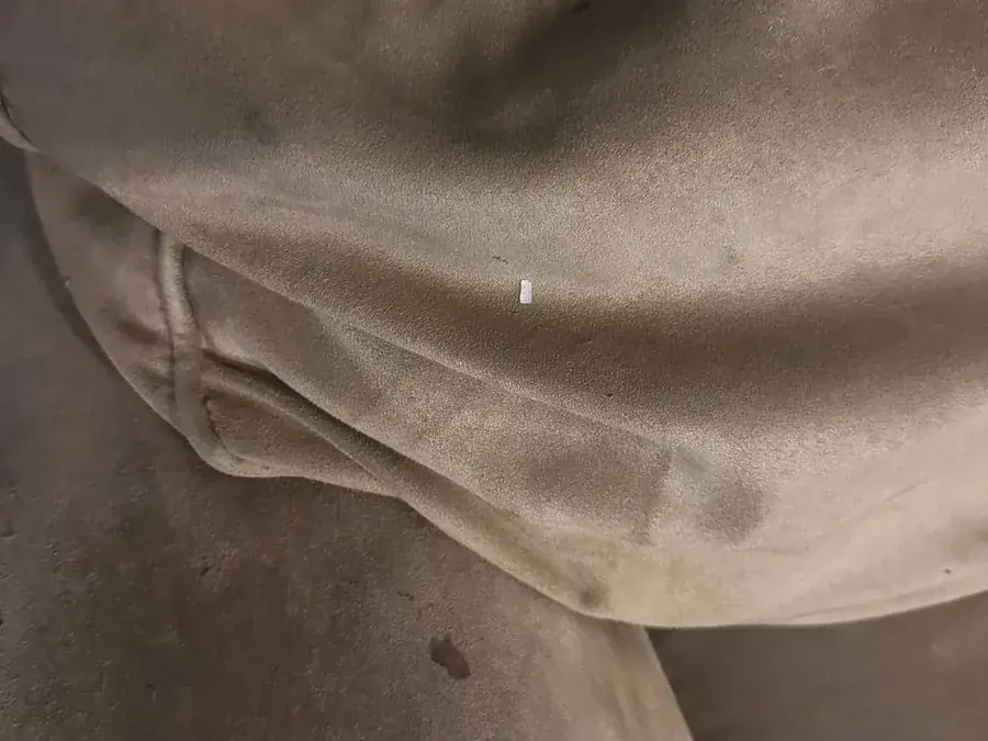 Close-up of dark soiling and spots on the microsuede cushions before cleaning