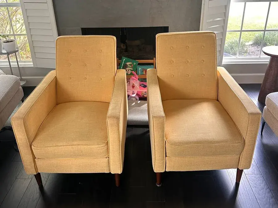 Two yellow fabric armchairs with dirt, food and marker stains before cleaning in a Houston living room