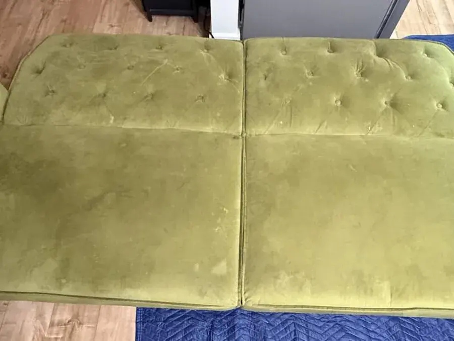 Green velvet sofa before cleaning, with water marks and soiling